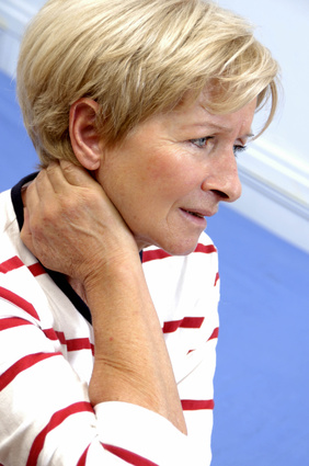 Femme qui se tient le cou après une entorse cervicale et qui consulte un ostéopathe